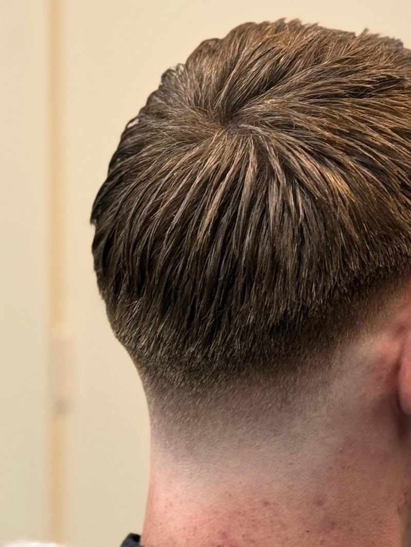 Korte fade in de nek met lengte bovenop, van achteren gezien